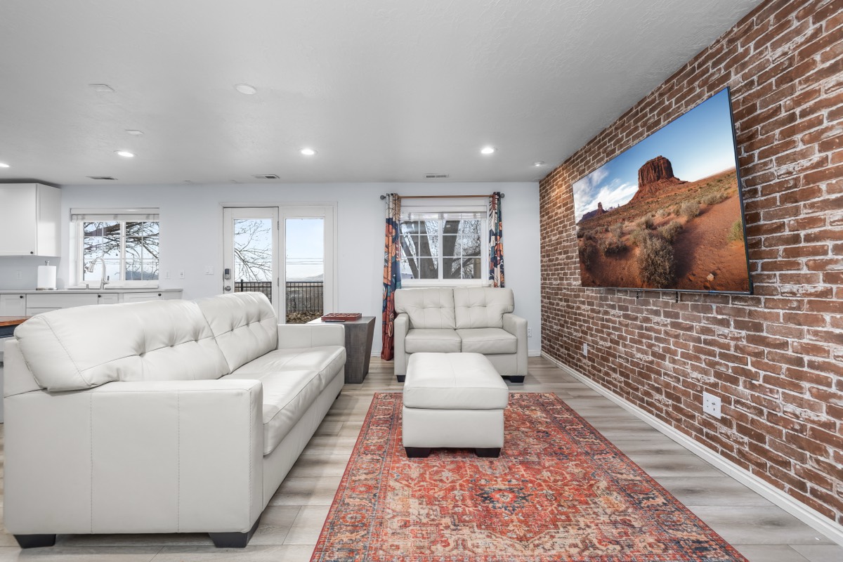 Modern living room with exposed brick wall and white leather sofas